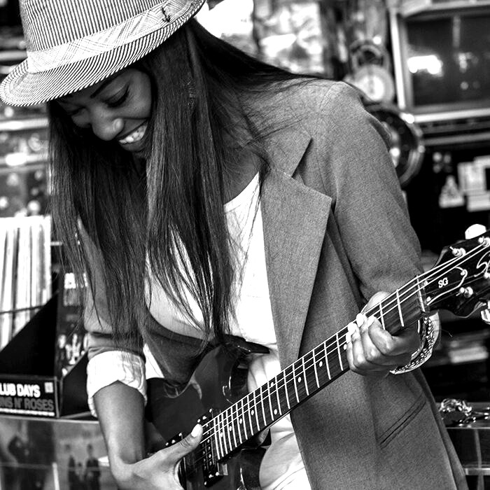 Black-and-white guitarist practicing hands-on learning for Spark Academy